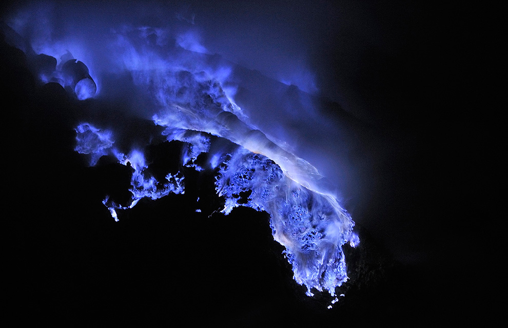 Горящая расплавленная сера течет по кратеру вулкана. Температура плавления серы 115°C. Температура в кратере недостаточно высока для самовоспламенения - огонь загорелся от факела рабочего.
